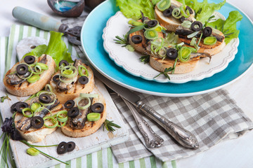 Crostini with fish with olives, cheese and chives