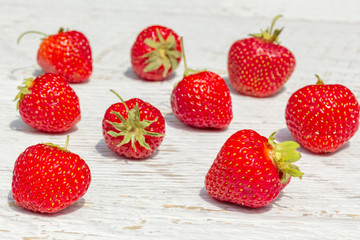 Red strawberries on a white wooden background