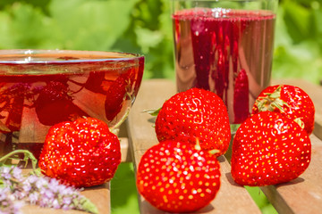 Strawberries, jam and juice on the table in the garden