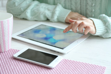 Woman using digital tablet on table close-up