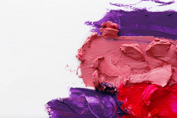 Smudged colourful lipstick on white background, close up