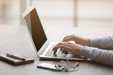 Woman's hands using laptop at the table