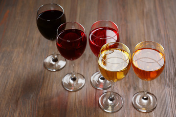 Glasses with wines of different colors on a wooden table