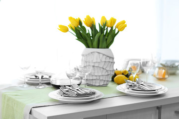 Table served with dishes and a bouquet of tulips