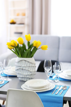 Table served with dishes and a bouquet of tulips