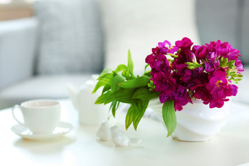 Vase with flowers on the table in the room