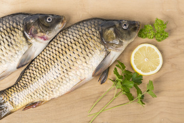 Fresh carps with lemon slice and herb on wood table