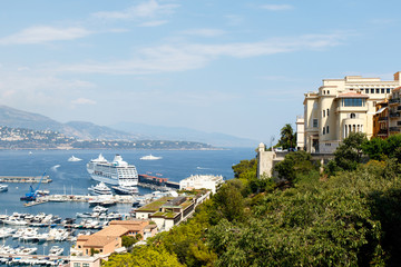 Fototapeta premium Monte Carlo harbor with the ancient Prince's Palace of Monaco, luxury yachts in the water, and the city skyline