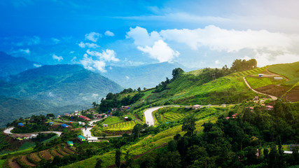 Switchback and village on mountain with blue sky landscape