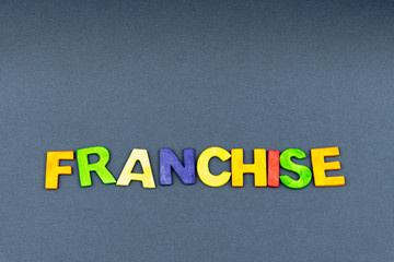 Word FRANCHISE created of wood letters on dark background