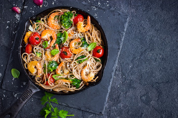 whole grain spaghetti pasta with shrimps and broccoli, top view