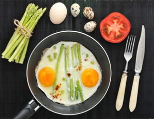 scrambled eggs in a frying pan with asparagus