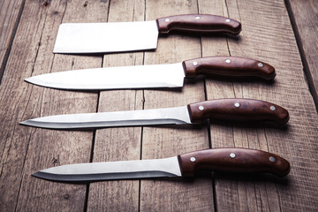 Beautiful knives with wooden handle, on an old table. Kitchen, c