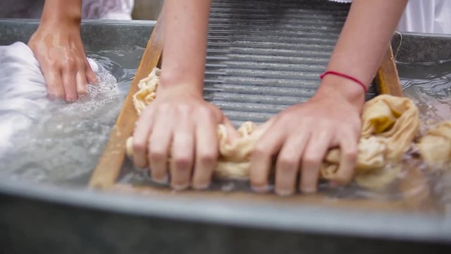 women wash using a old fashioned washboard 