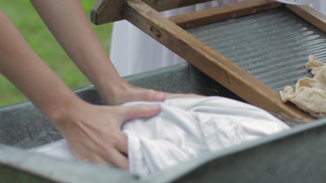 women wash using a old fashioned washboard 