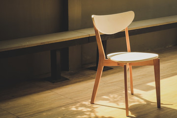 White wooden chair under sunlight retro dark tone 