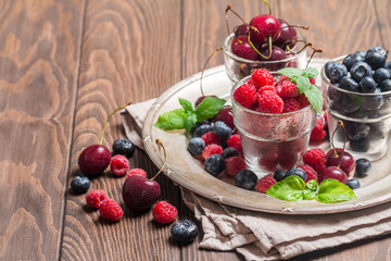 small glasses of fruit containing cherry, blueberry and rasberry