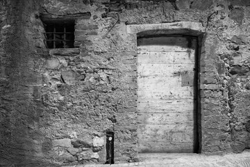 black and white - old door and window of brick building