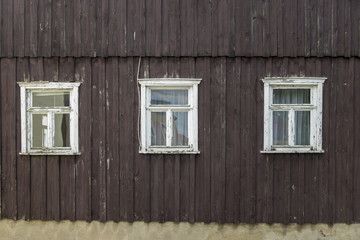 Obraz na płótnie Canvas three windows in a wooden wall