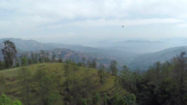 Aerial view of Dhulikhel district in the Kathmandu valley, Nepal. Raven flying close to the drone.
