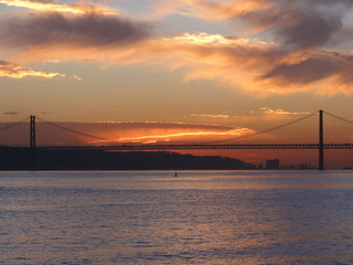 sunset over the 25th of April Bridge in Lisbon , Portugal