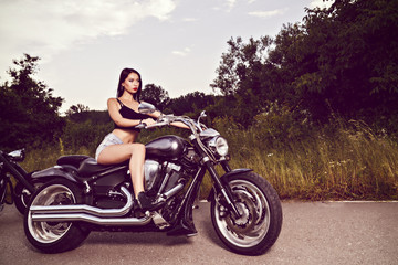 Fototapeta na wymiar beautiful young woman posing with a motorcycle