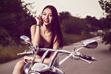Fototapeta na wymiar beautiful young woman posing with a motorcycle