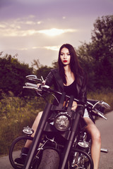 Fototapeta na wymiar vintage image of a beautiful woman sitting on a motorcycle and s