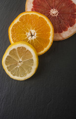 Naklejka na ściany i meble Citrus fruit cut in half - oranges, grapefruit ,lemon on a black background