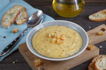 Bowl of zucchini and cauliflower cream soup on wooden table. Hea