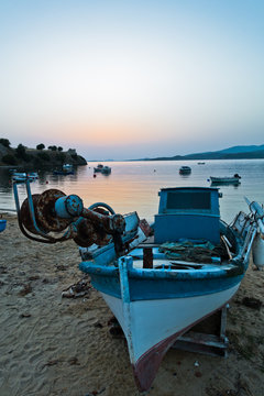 Fishing Boat On A Beach In Front Of Ruins Of A Roman Fortress At Sunset, Sithonia, Greece