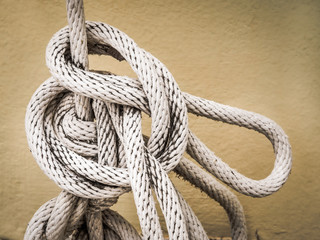 Close up of white rope And Knot on yellow cement wall