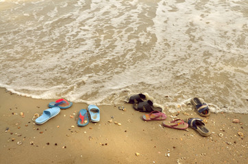 Fototapeta na wymiar shoes on sand beach in relaxing holiday concept