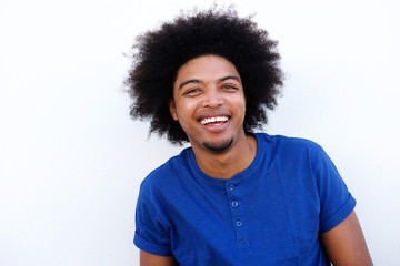 Young black man laughing against white background