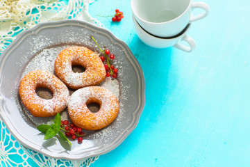 Homemade donuts in a gray plate on a blue wooden background