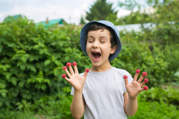 Cute little boy glad to have a many berries