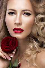 Fototapeta na wymiar Beautiful blonde in a Hollywood manner with curls, red lips. Beauty face.