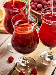 On wooden boards are group ice cold beverage glass with red raspberry lemon cocktail . Alcohol country cocktail beverage number hundred with lemon . Top view cocktail .