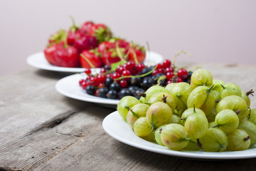 Summer berries on a wooden table.Goosbery, strawberry,black, red
