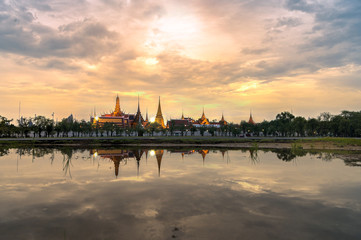 Naklejka premium Grand palace and wat phra kaew temple and royal grand palace in the evening has reflection in the puddle after the rain. selective focus at wat phra kaew temple. Process day to night technique.