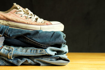 Jeans with shoe on wooden table dark background 