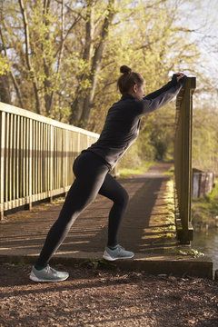 Young woman stretching while exercising outdoors