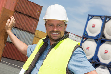 Engineer with helmet and truck and container in cargo