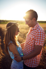Couple in love enjoying tender moments during sunset . Emotional concept of relationship with travel boyfriend and girlfriends relaxing together. guys are walking in wheat
