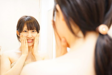 鏡の前でスキンケアをする若い日本人の女性 美容 化粧 ミラー 一人暮らし 美人 美肌