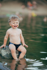 little funny boy playing in water