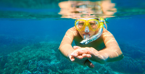 Woman with mask snorkeling in clear tropical water - obrazy, fototapety, plakaty
