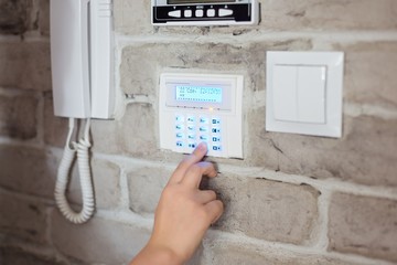 Little baby boy pushes a buttons on the alarm keypad