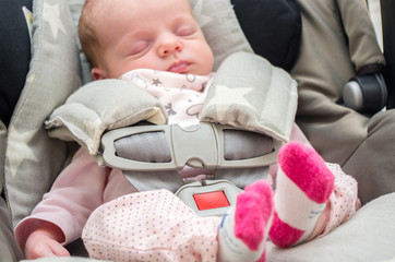 newborn baby girl in a car seat