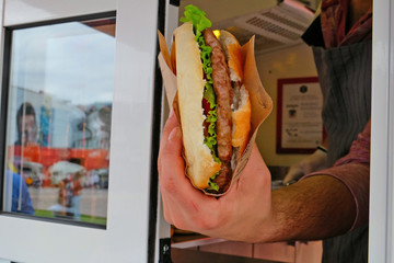 seller of street cafes, transmits the ready Burger to the buyer